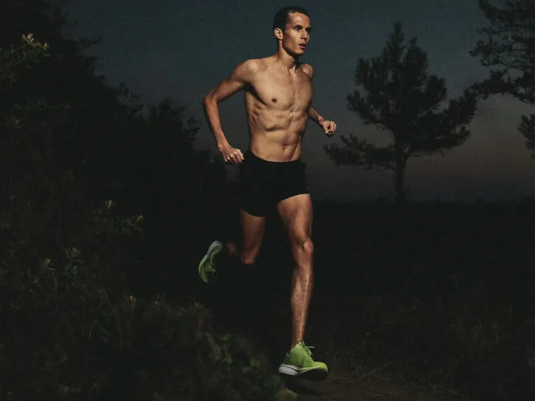 A man runs a trail at nightfall